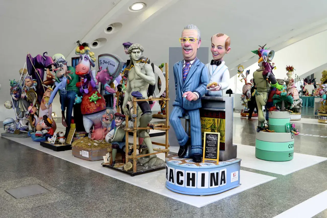Exposición del ninot con figuras satíricas, incluyendo una parodia de David, políticos y animales. ¡Una obra maestra de la crítica social!