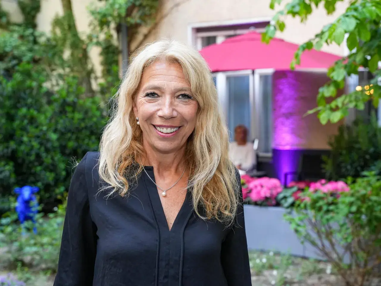 Glückliche Frau mit blonden Haaren und Perlenkette, vielleicht bei einer Feier wie der lisa federle hochzeit.