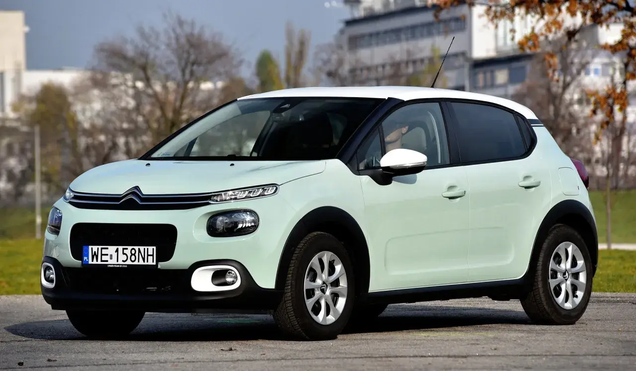 Jasnozielony Citroen C3 z białym dachem, na którym opony wyglądają na zimowe. Idealny do miasta, ale jakie opony wybrać na dalsze trasy?
