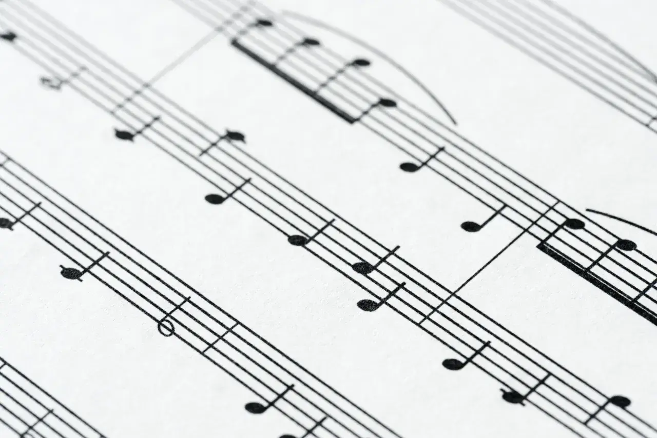 Zbliżenie na pięciolinię z nutami. Położenie nut na pięciolinii jest kluczowe do odczytania melodii.