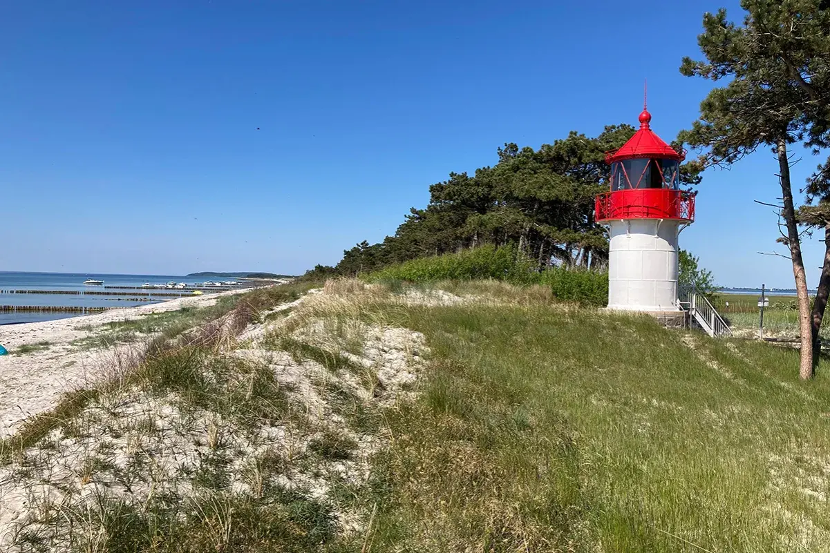 Leuchtturm auf Hiddensee, autofrei und idyllisch. Strand, Meer und Kiefernwald bilden die Kulisse für diesen friedlichen Ort.
