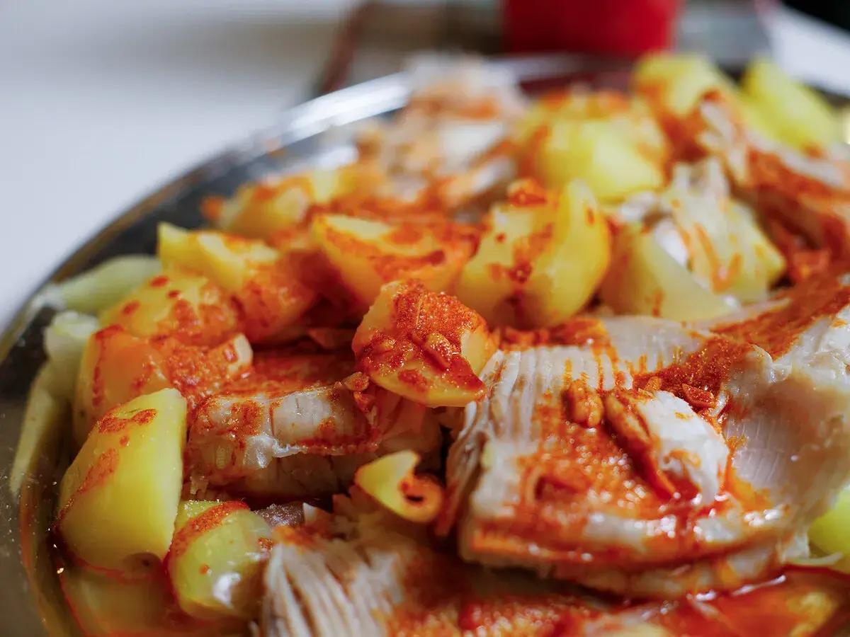 Raya a la gallega, un plato tradicional con trozos de pescado blanco y patatas cocidas, espolvoreado con pimentón.