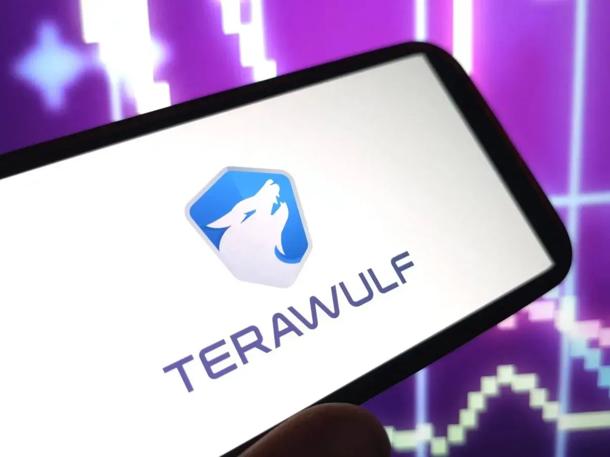 Smartphone zeigt das Logo und den Namen "TERAWULF" vor einem lila Börsenchart. Die Terawulf Aktie im Fokus.