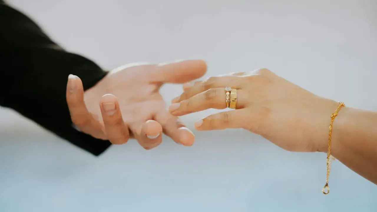 Manos entrelazadas, anillos de oro simbolizan una boda de oro, ¡cuántos años son 50 de amor y compromiso!