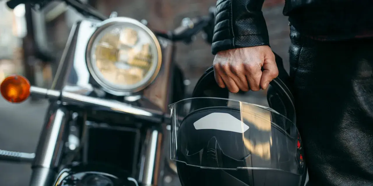 Motociclista con casco negro, listo para aprender como dar de baja una moto.