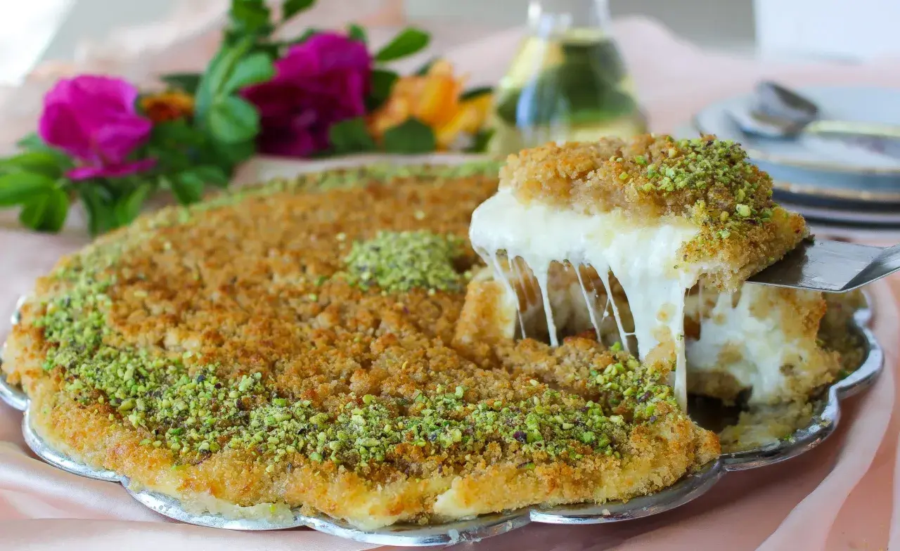 En bit krämig kunafa med smält ost som dras ut, toppad med pistagenötter. Ett läckert kunafa recept att prova!