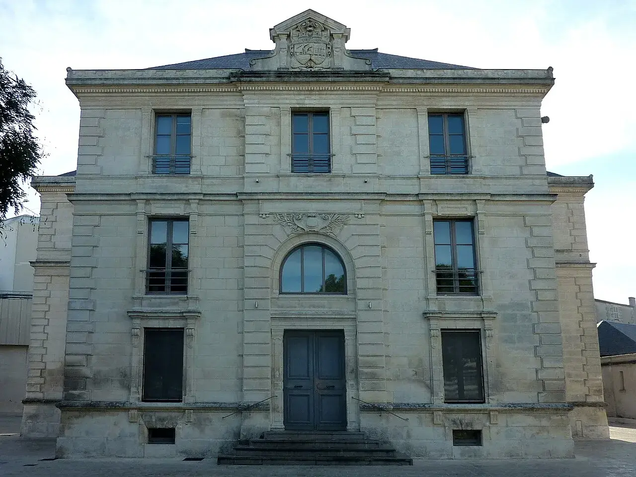 Bâtiment de l'état civil en Charente-Maritime, façade en pierre de taille avec une grande porte centrale et plusieurs fenêtres.