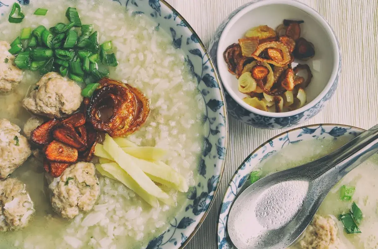 Pyszny congee z klopsikami, szczypiorkiem i chrupiącą cebulką. Idealne na rozgrzewający posiłek.