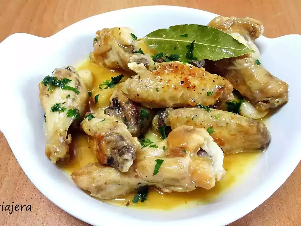 Alitas de pollo al ajillo, doradas y jugosas, bañadas en una salsa aromática con ajo y perejil fresco. Un plato delicioso.