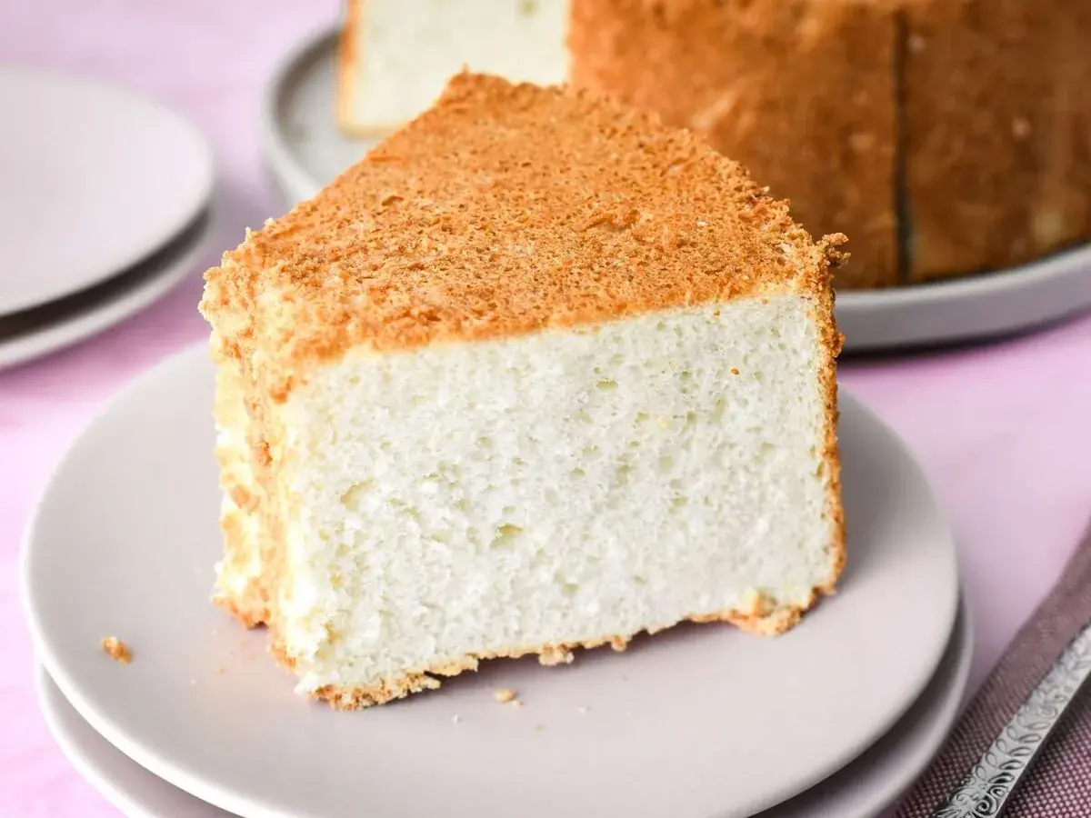 Una fetta soffice di angel cake, con la sua crosticina dorata, pronta per essere gustata.