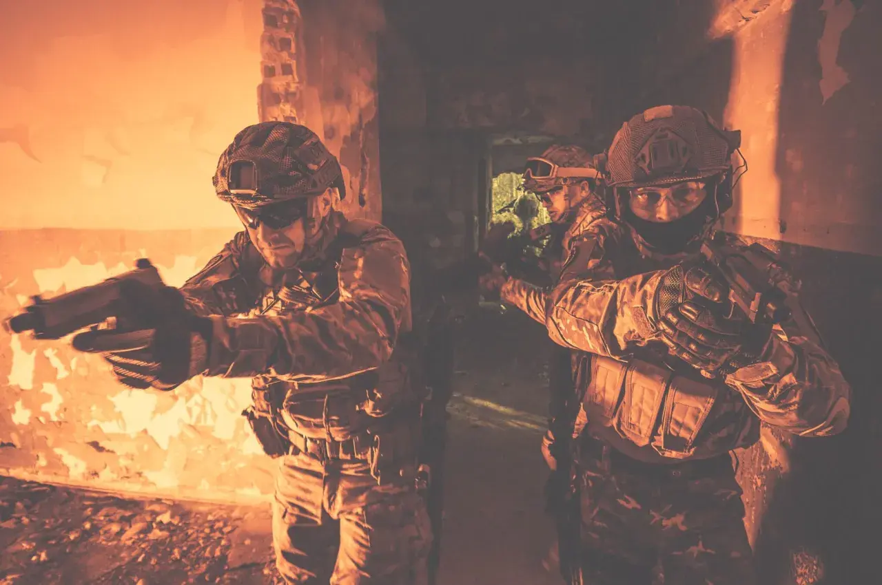Żołnierze w taktycznym kamuflażu, z bronią w rękach, ćwiczą **CQB co to** jest walka w bliskim kontakcie w ciasnych pomieszczeniach.