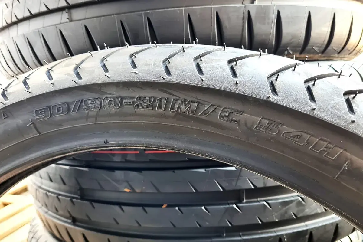 Opona motocyklowa z oznaczeniem 90/90-21. Różnica między profilem 65 a 70 jest kluczowa dla komfortu jazdy.