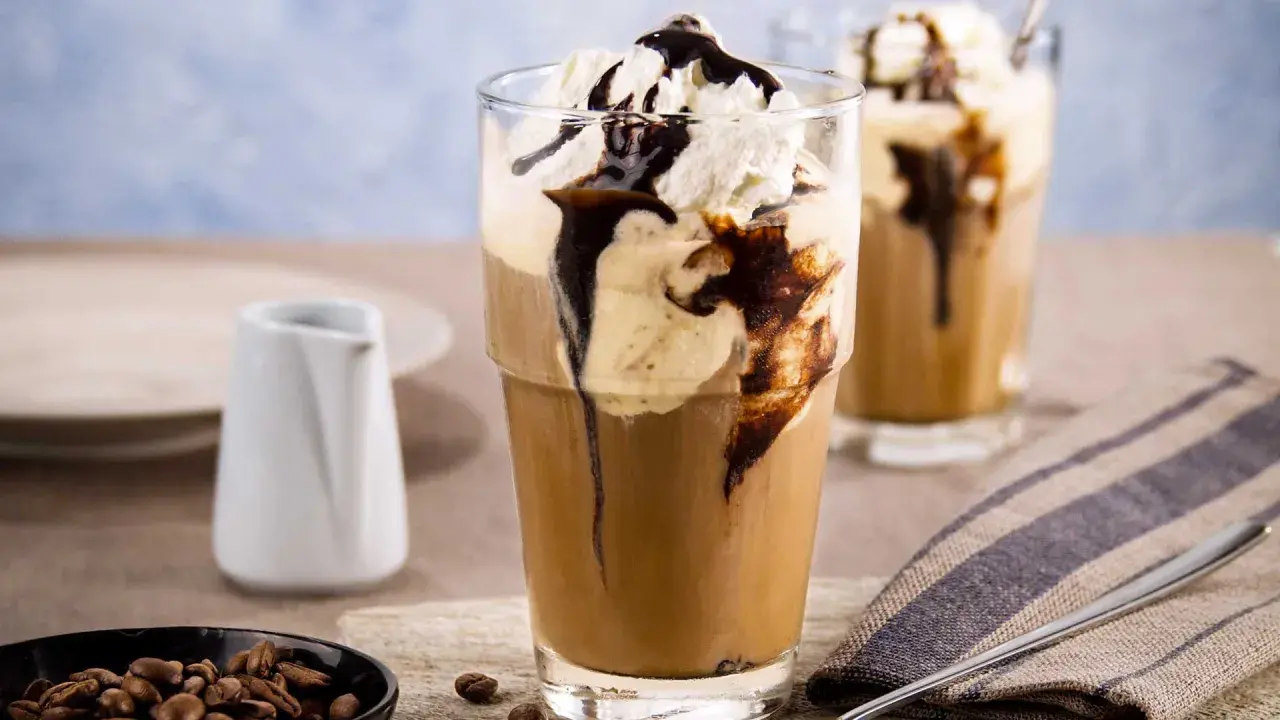 Ein erfrischender Eiskaffee mit Vanilleeis, garniert mit Sahne und Schokoladensauce. Perfekt für einen warmen Tag.