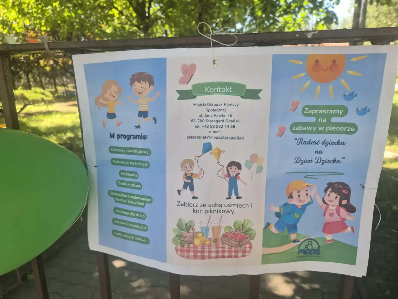 Plakat zapraszający na plenerowe zabawy z okazji Dnia Dziecka, organizowane przez MOPS Starogard Gdański. W programie m.in. malowanie twarzy, bańki mydlane i zabawy integracyjne. To wspaniały projekt socjalny!