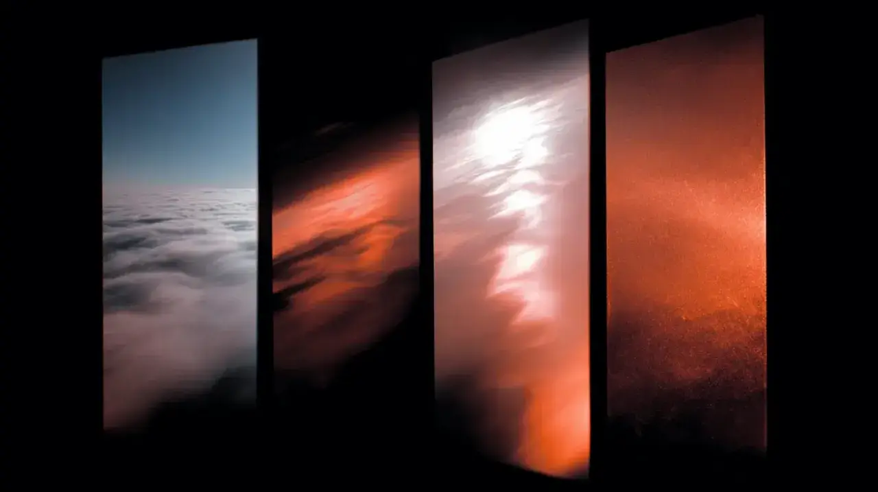 Quattro pannelli verticali mostrano un cielo che sfuma dal blu al giallo e rosso, con nuvole che cambiano colore.