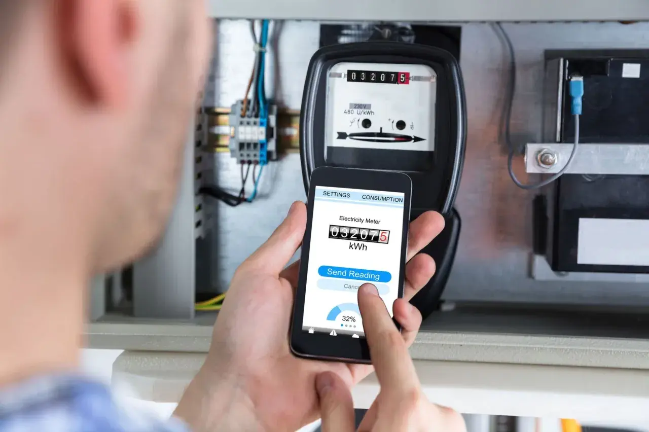 Zdalny odczyt licznika energii elektrycznej za pomocą smartfona. Na ekranie telefonu widoczny jest aktualny stan licznika.