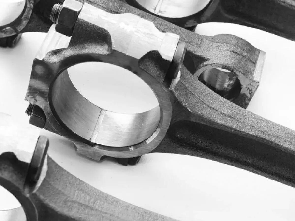 Primer plano de bielas de coche, componentes esenciales que conectan el pistón al cigüeñal, permitiendo el movimiento rotatorio del motor.