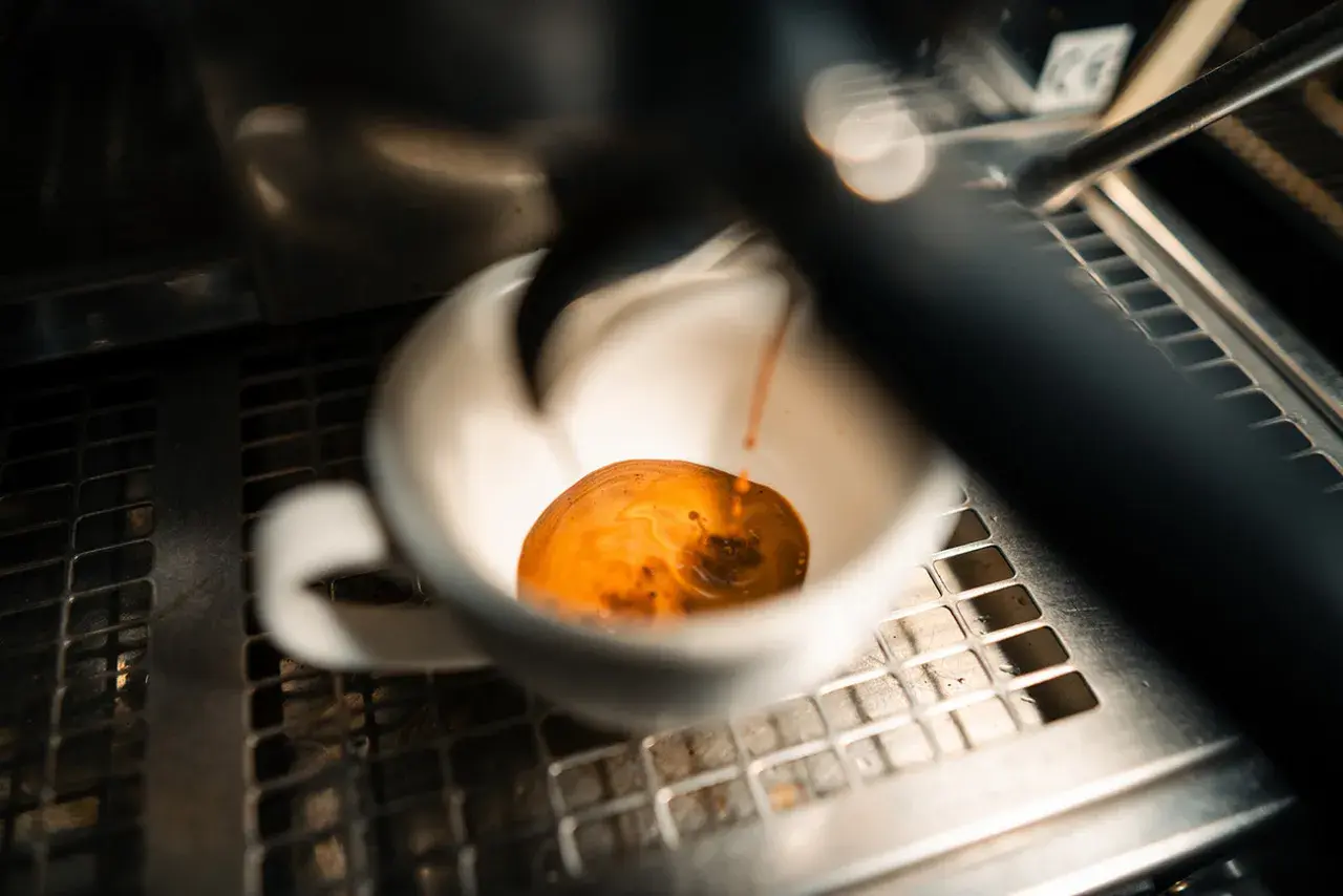 Frisch gebrühter Espresso fließt in eine weiße Tasse. Manche sagen, entkoffeinierter Kaffee sei krebserregend, aber dieser hier sieht köstlich aus.