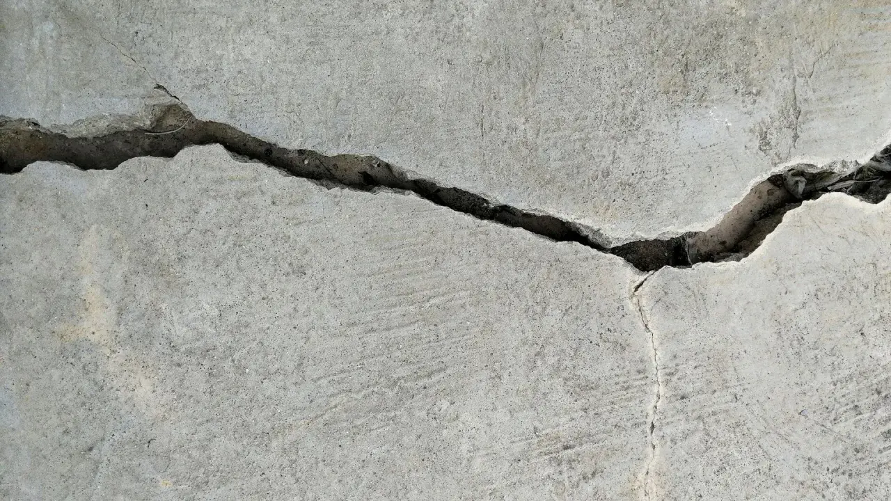 Pęknięcie w betonie, gdzie widać drobne włókno polimerowe wzmacniające strukturę.