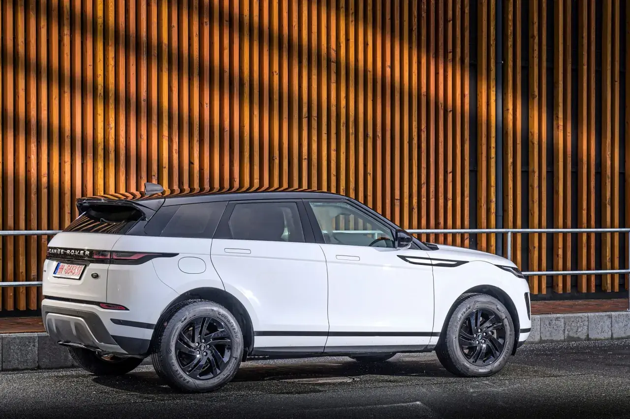Weißer Range Rover Evoque 2.0 Diesel, moderne Optik vor Holzfassade. Gute Range Rover Evoque 2.0 Diesel Erfahrungen gesucht?