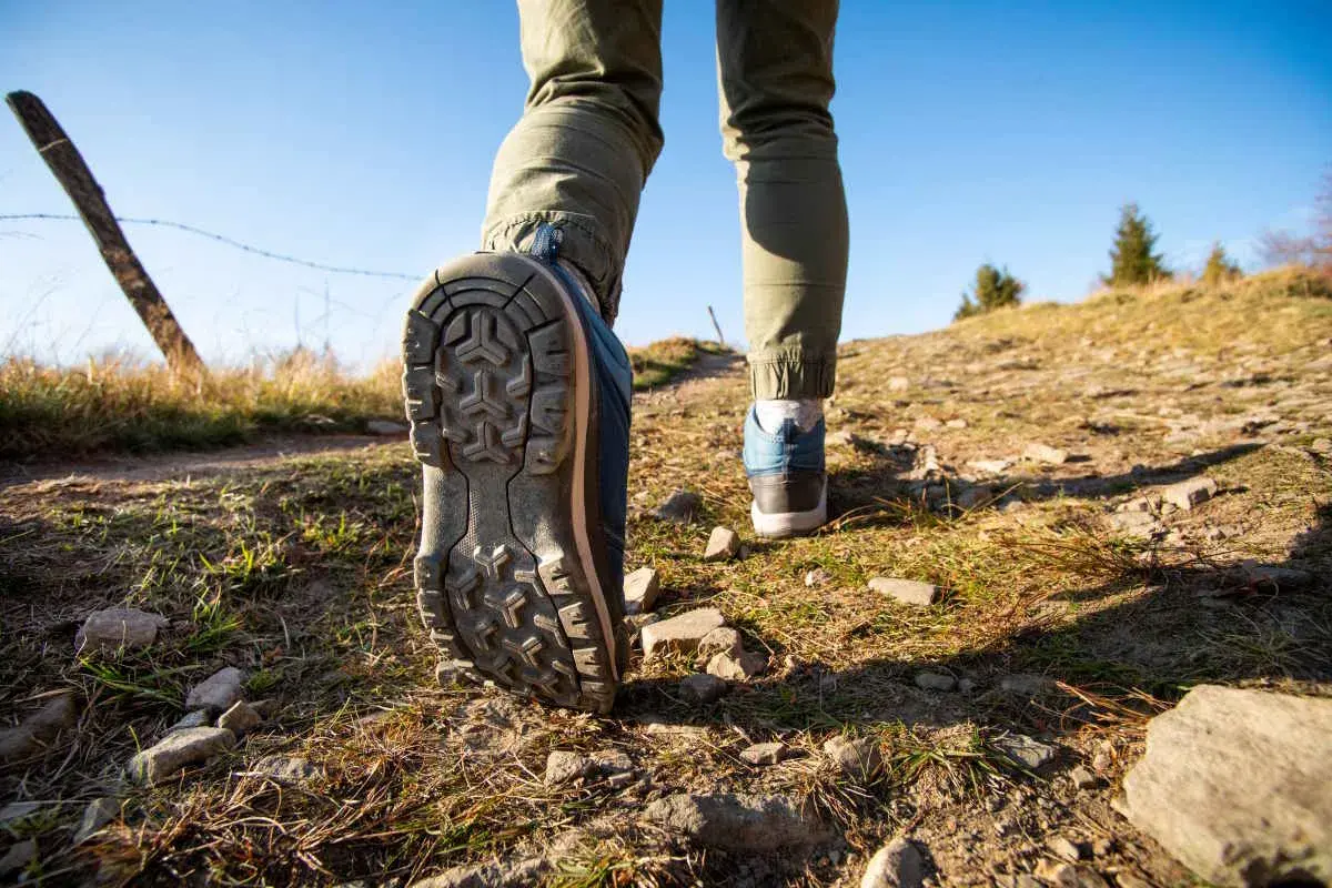 Dobre buty w Tatry to podstawa! Widok na szlak, gdzie stopy w solidnych trekkingowych butach stawiają kolejne kroki.