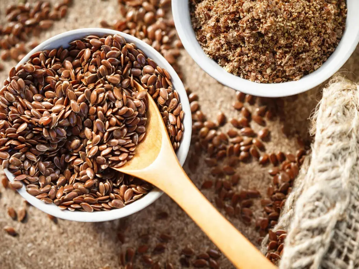 Schüssel mit ganzen Leinsamen und gemahlenen Leinsamen. Leinsamen roh essen ist gesund!