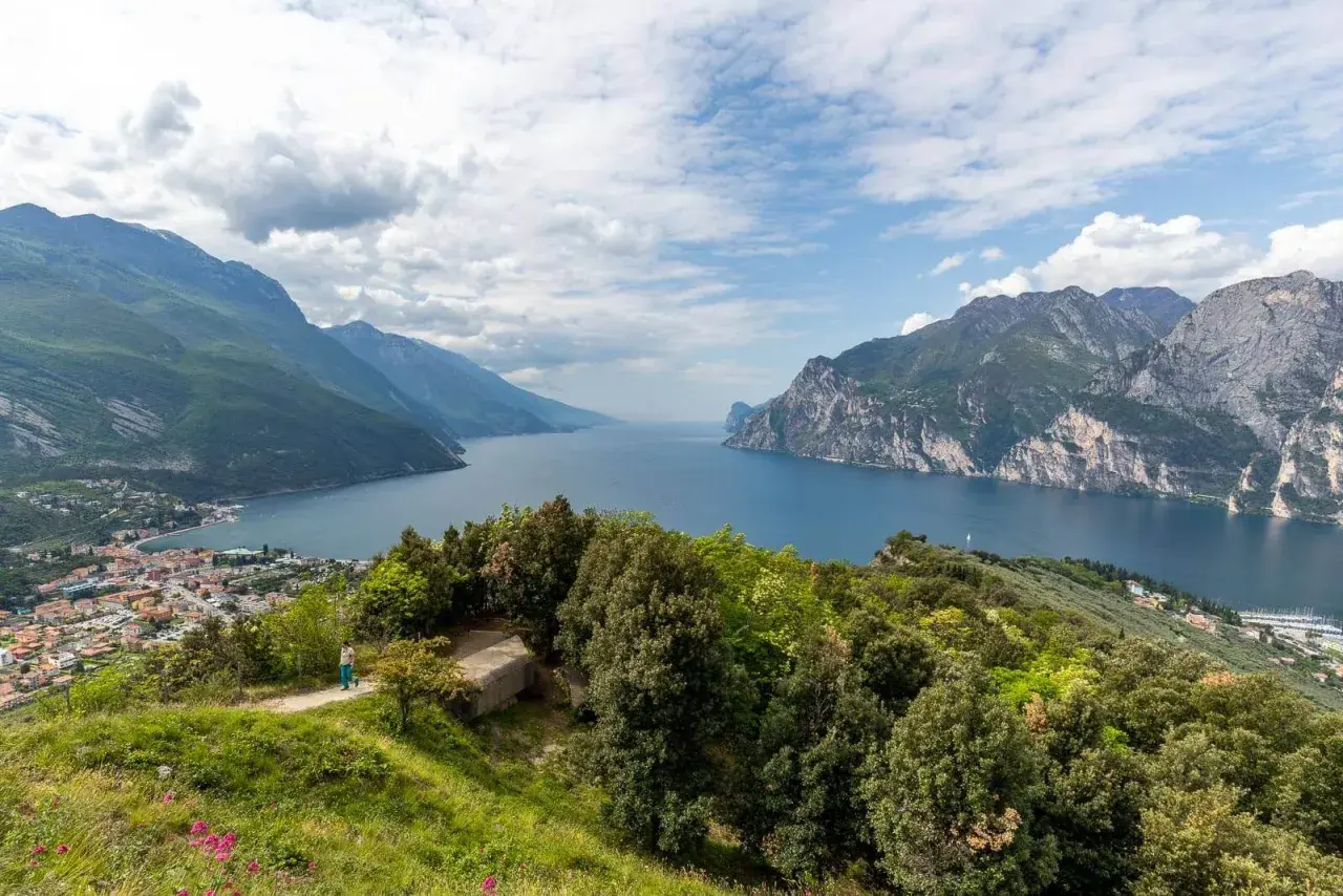Panoramica mozzafiato del Lago di Garda, ideale per **leichte wanderungen am Gardasee**. Montagne verdi e rocciose incorniciano il blu intenso dell'acqua.