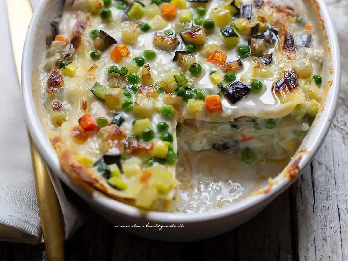 Lasagne alle verdure ricetta della nonna: strati di pasta, besciamella cremosa e un ricco mix di zucchine, carote, melanzane e piselli, gratinate al forno.