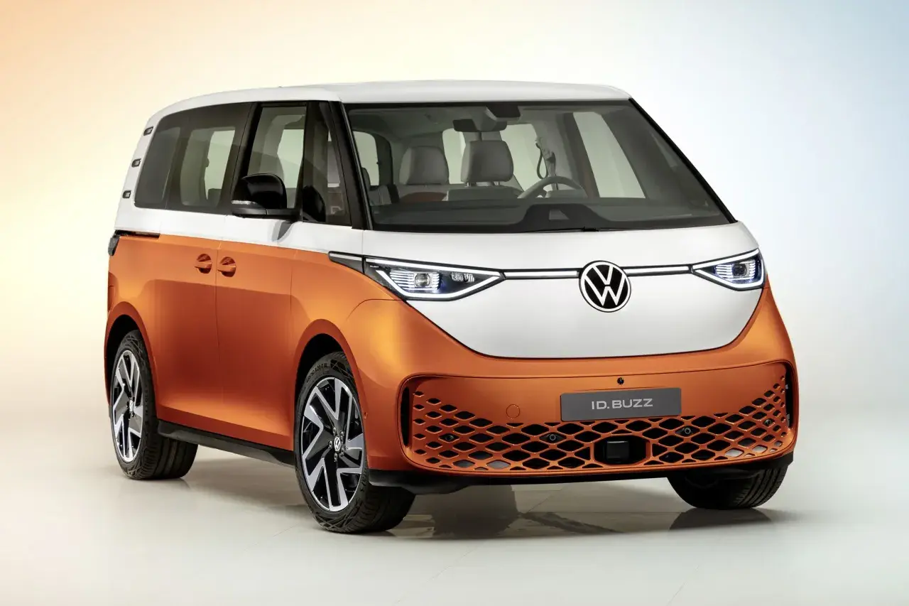 Il Volkswagen ID. Buzz, un furgone elettrico bicolore arancione e bianco, pronto per un viaggio pieno di energia.