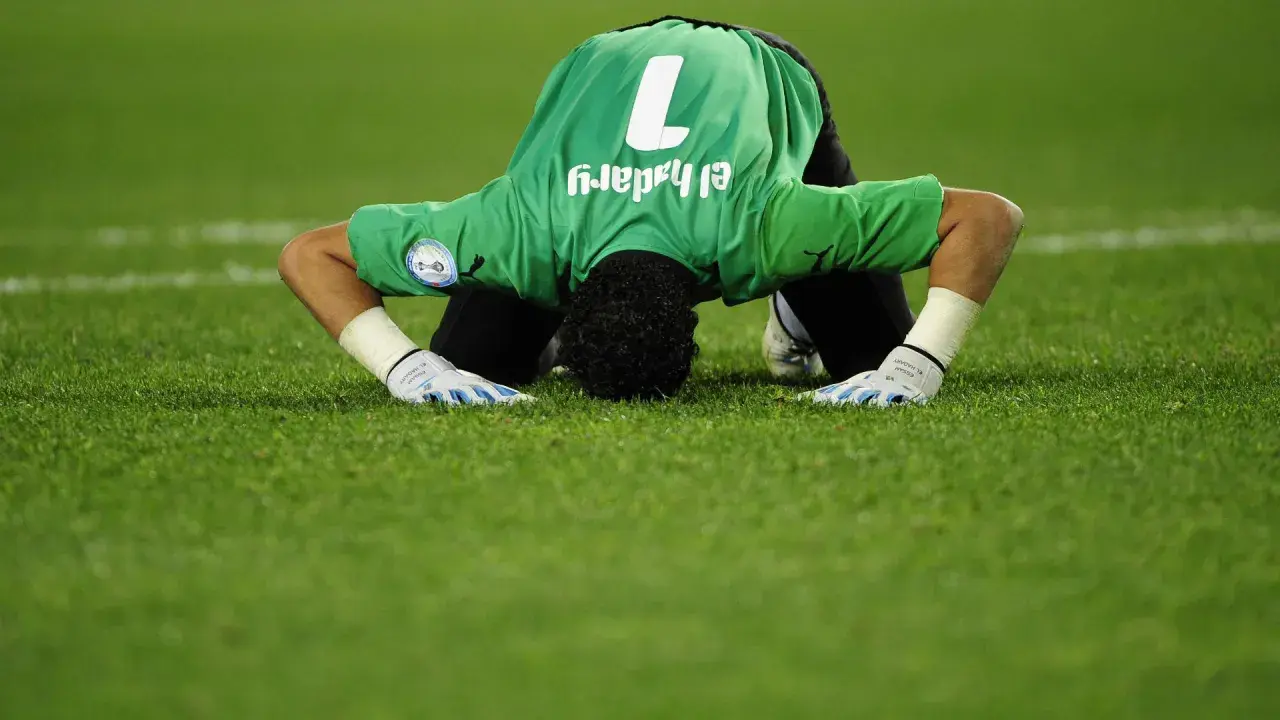 Bramkarz w zielonej koszulce z numerem 1, Essam El-Hadary, najstarszy piłkarz na mundialu, klęczy na murawie.