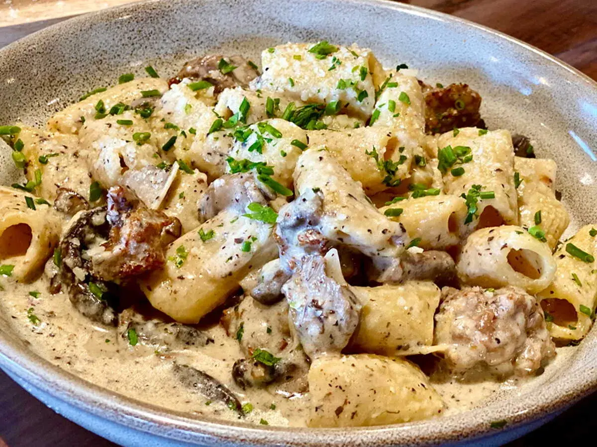 Un plat de pâtes aux champignons, une recette italienne crémeuse et savoureuse, garnie de persil frais.