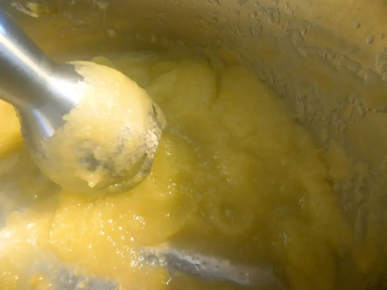 Blendowanie parowanej cukinii na puree dla niemowlaka. Zdrowy, żółty posiłek gotowy do podania.