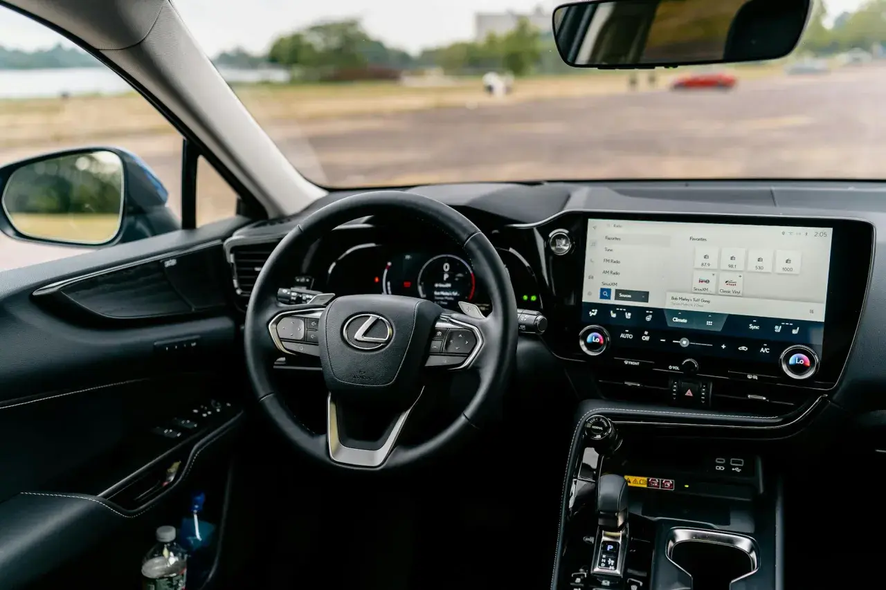Wnętrze Lexusa z ekranem multimedialnym, na którym widać opcje radia i nawigacji, sugerujące android auto aktualizacja.