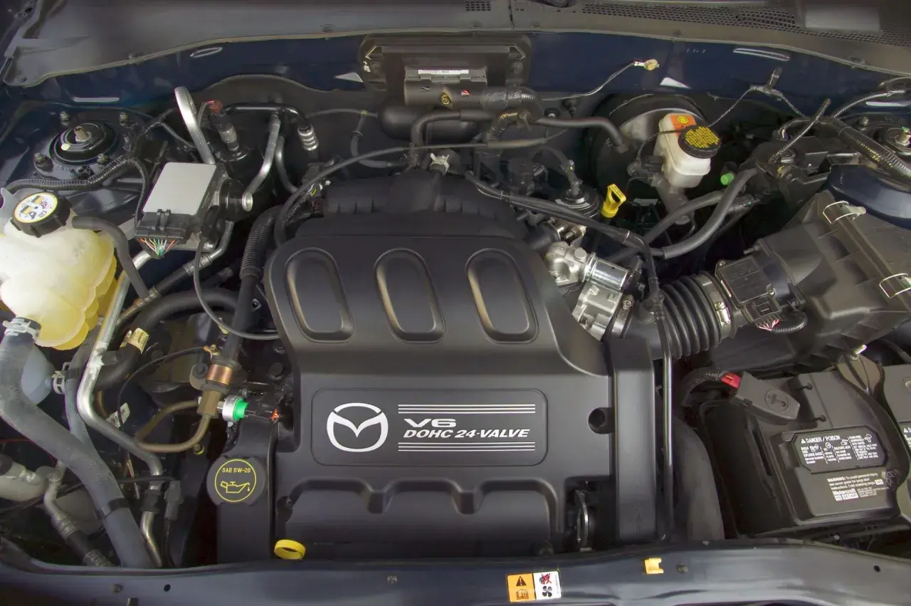 Silnik V6 DOHC 24-zaworowy w Mazda Tribute. Widoczny zbiornik płynu chłodniczego, akumulator i elementy układu dolotowego.