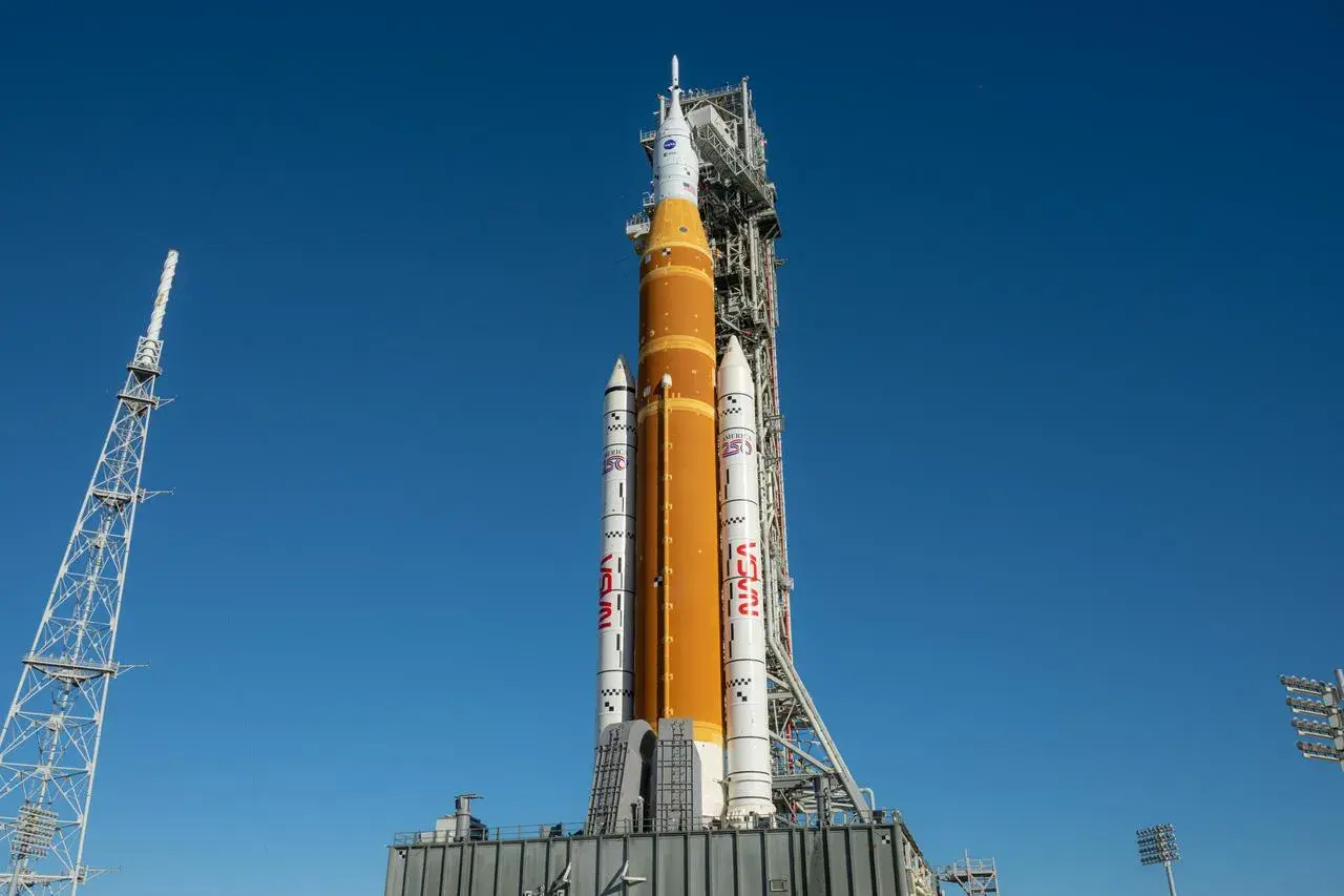 Potężna rakieta NASA Space Launch System (SLS) gotowa do startu. Dwa potężne boostery rakietowe po bokach centralnego zbiornika paliwa.