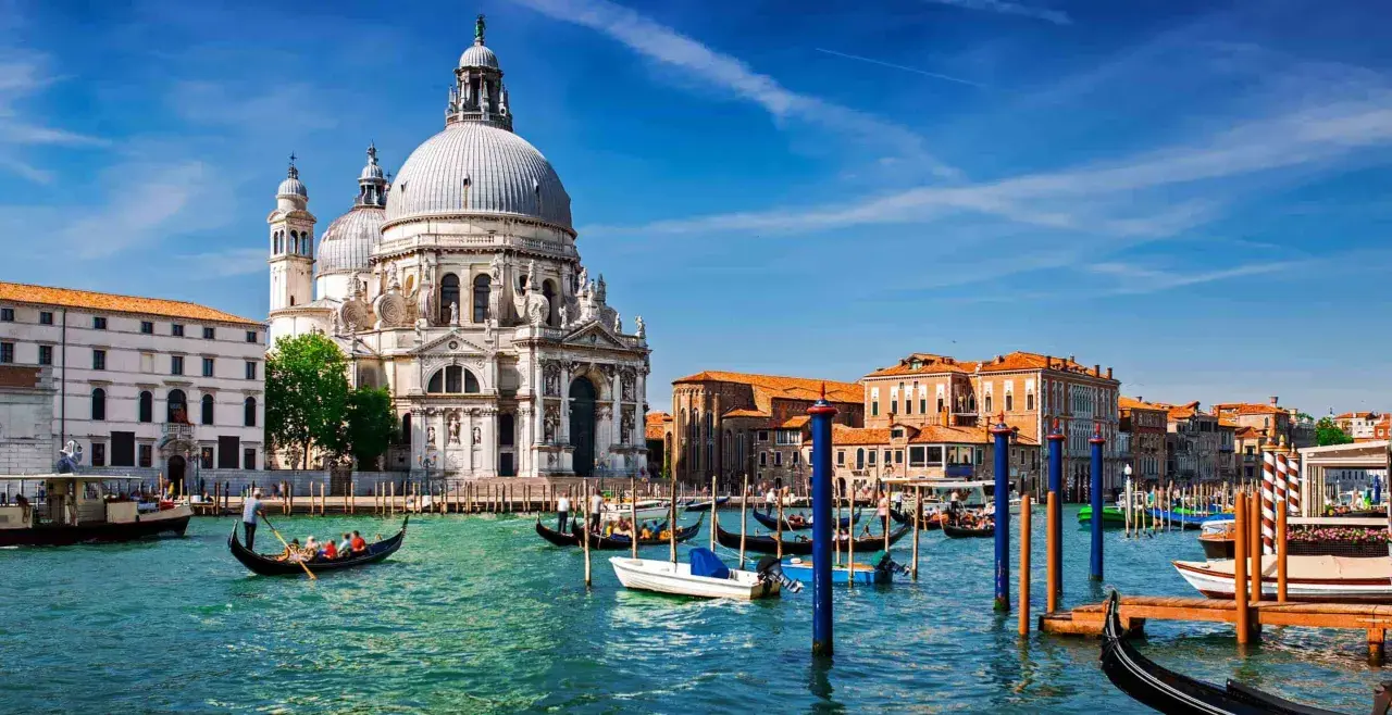 Gondole płynące po wodzie przed Bazyliką Santa Maria della Salute. Tak właśnie wygląda Wenecja, miasto na wodzie.