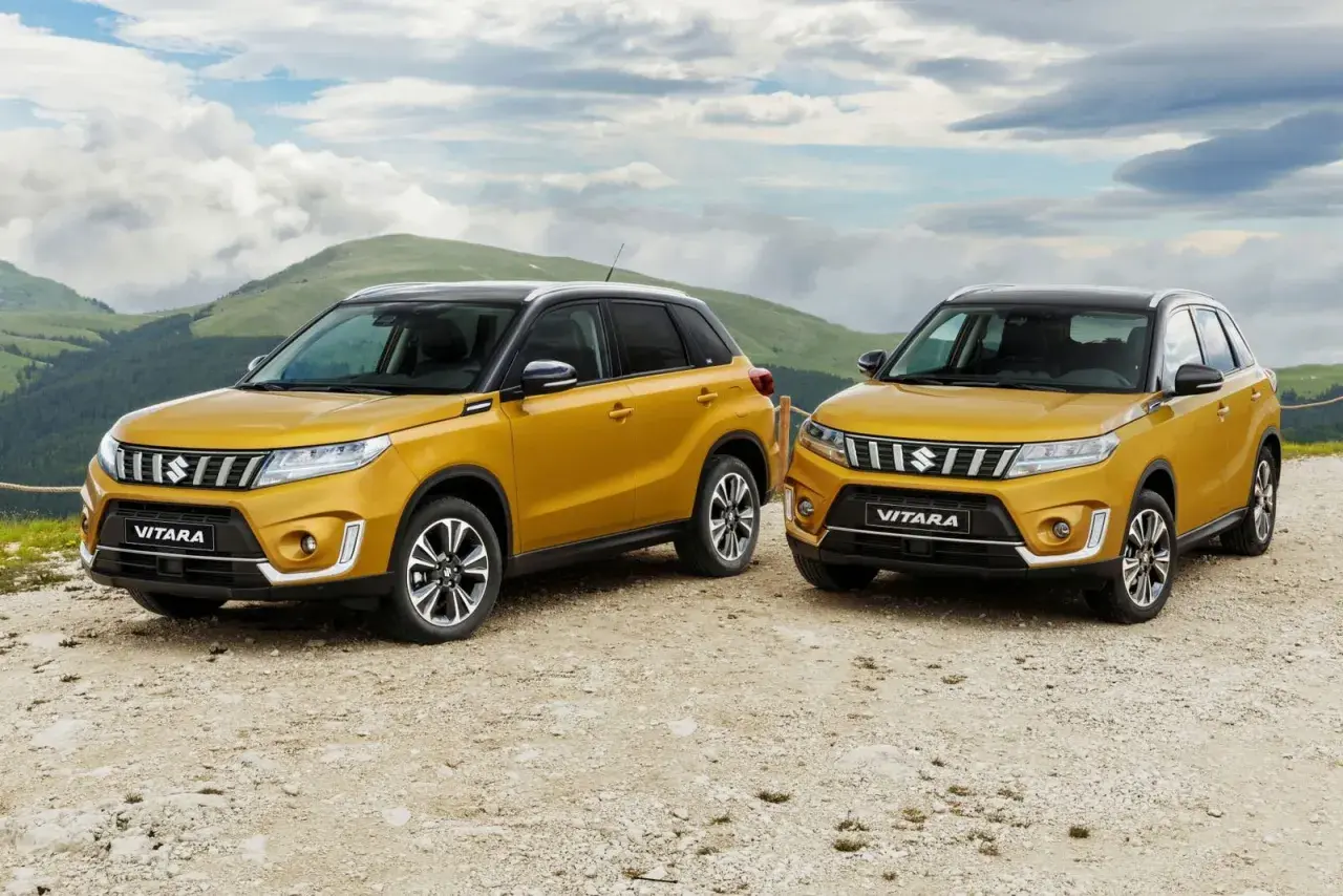 Dos Suzuki Vitara amarillos listos para la prueba en un paisaje montañoso.