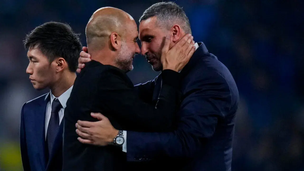 Pep Guardiola i Ryan Giggs w uścisku, symbolizującym szacunek i rywalizację, która wpływa na rankingi Man City.