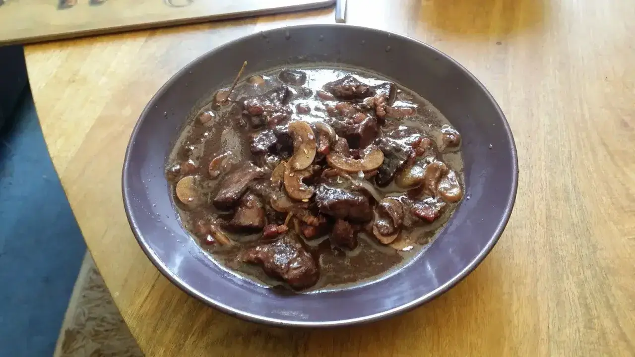 Un plat de bœuf mijoté dans une sauce riche, avec des champignons et des lardons. Un vrai délice pour un bourguignon, parfait avec un bon vin pour bourguignon.