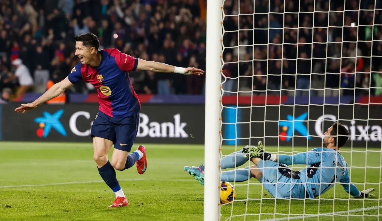 Piłkarz świętuje gola w meczu La Liga, bramkarz leży na ziemi.
