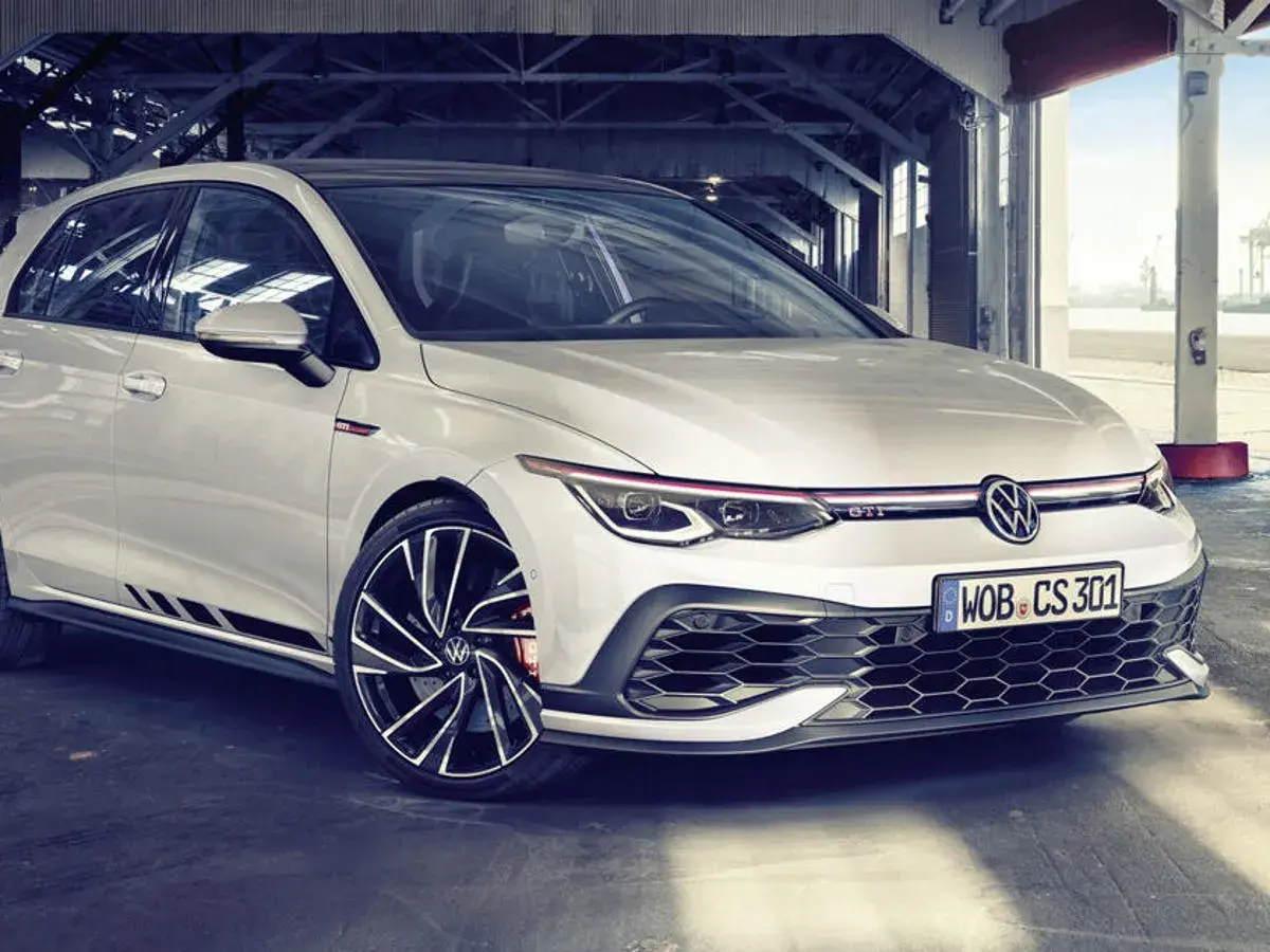Weißer Golf GTI Performance mit sportlichen Akzenten und auffälligen Felgen, bereit für die nächste Fahrt.