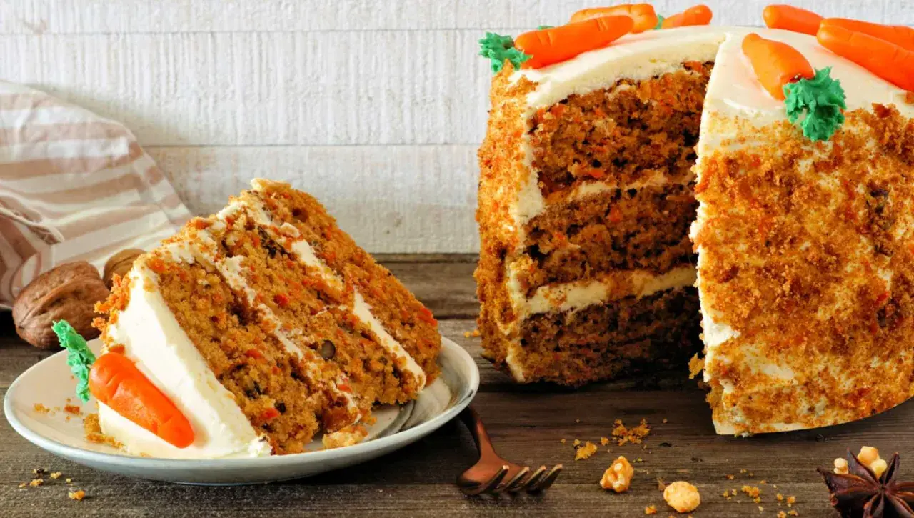 Delicioso carrot cake receta original inglesa, con capas de bizcocho y crema, decorado con zanahorias de mazapán.