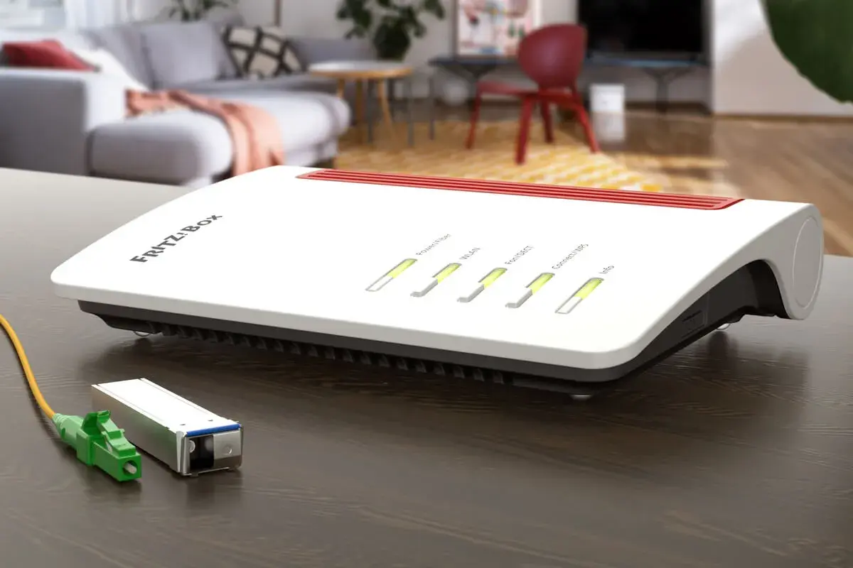 Router FRITZ!Box z zielonym złączem światłowodowym obok. Gotowy do szybkiego internetu.