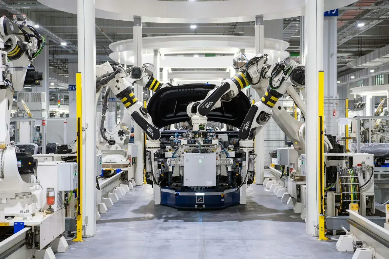 Roboterarme montieren ein Autoteil in einer Fabrik. Bosch KI steuert die präzisen Bewegungen.