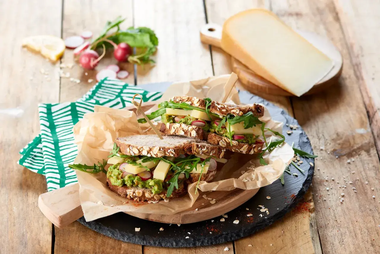 Une idée de sandwich gourmande : pain aux céréales, avocat, fromage, radis et roquette. Parfait pour un repas sain et savoureux.