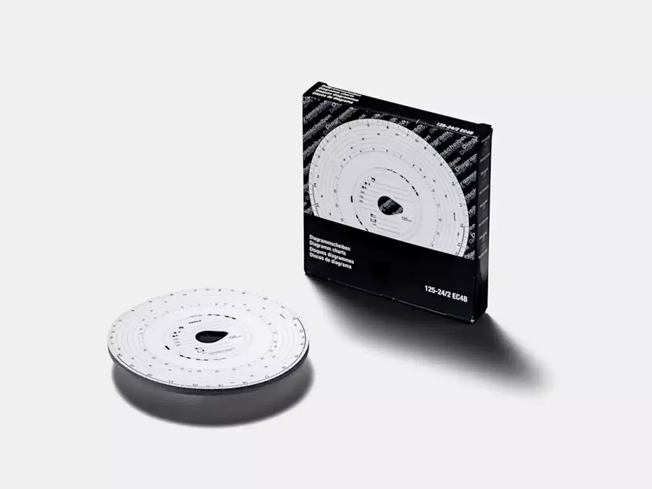 Un chronotachygraphe analogique, avec sa boîte et un disque de diagramme, prêt à enregistrer les trajets des véhicules.