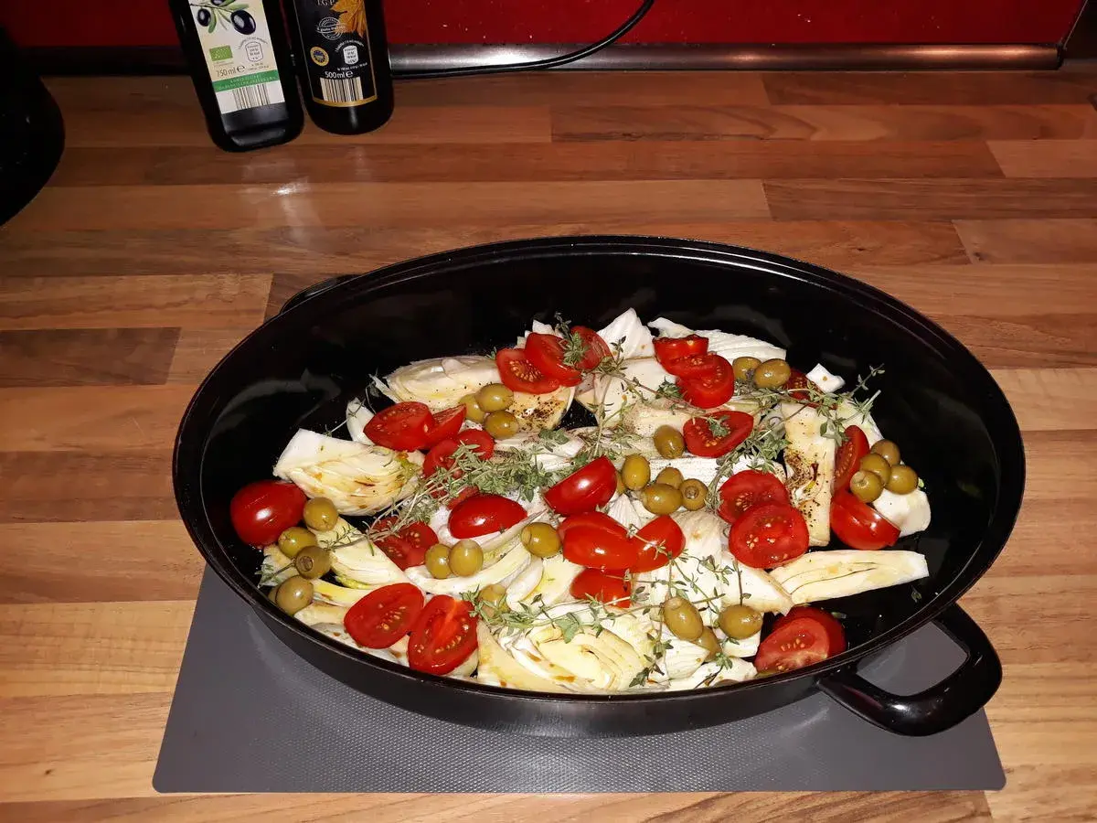 Fenchel-Rezepte: Fenchelspalten mit Kirschtomaten und Oliven in einer Auflaufform, bereit zum Backen.
