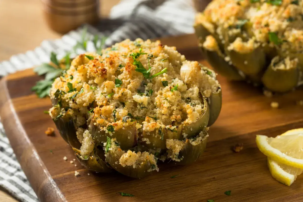 Carciofi ripieni e dorati, cotti alla perfezione nella friggitrice ad aria, guarniti con prezzemolo fresco e spicchi di limone.