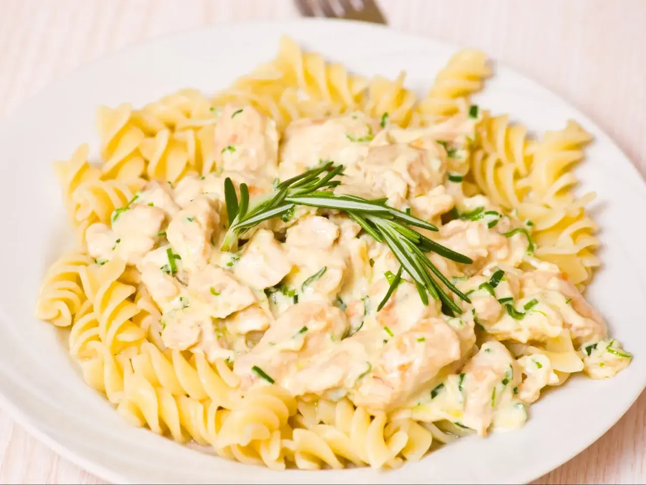 Fusilli z kurczakiem w kremowym sosie, udekorowane rozmarynem.