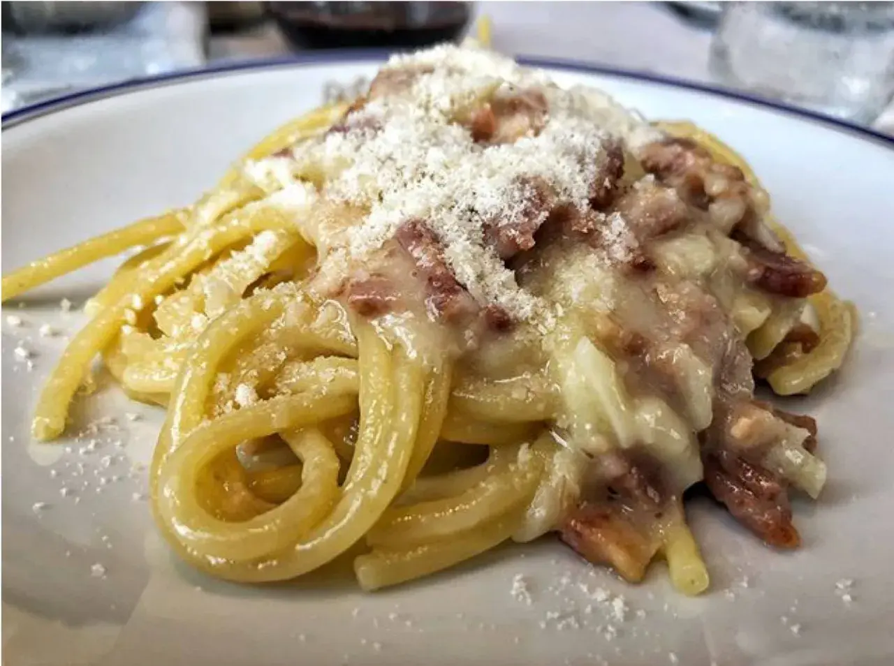 Un piatto di spaghetti alla carbonara, cremosi e ricchi di guanciale croccante, spolverati di pecorino.
